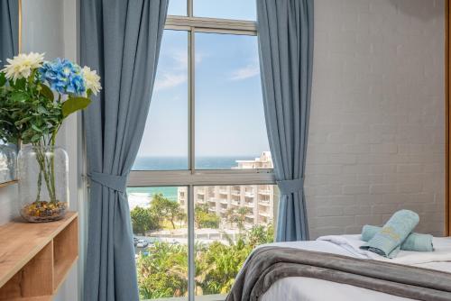 Un dormitorio con una ventana con vista al mar. en Trendy @ La Ballito 503, en Ballito