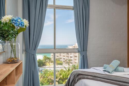 a bedroom with a window with a view of the ocean at Trendy @ La Ballito 503 in Ballito