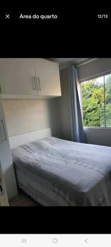 niewielka sypialnia z łóżkiem i oknem w obiekcie Apto Sirius 31 w mieście Cascavel