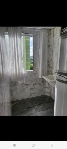 a bathroom with a window and a marble wall at Apto Sirius 31 in Cascavel
