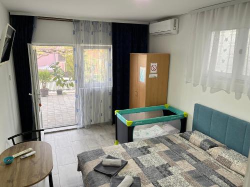 Cette petite chambre comprend un lit, une table et une fenêtre. dans l'établissement Apartmani Kalea, à Sokobanja