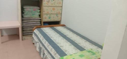 een kleine slaapkamer met een bed en een aantal vouwhanddoeken bij Sobey Laris Homestay PASIR MAS LATI in Pasir Mas