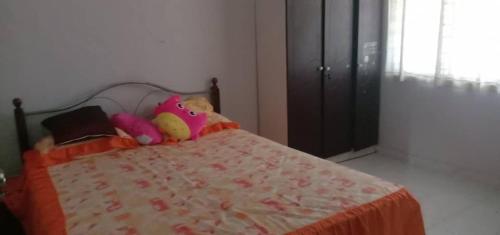 a stuffed animal sitting on top of a bed at Sobey Laris Homestay PASIR MAS LATI in Pasir Mas