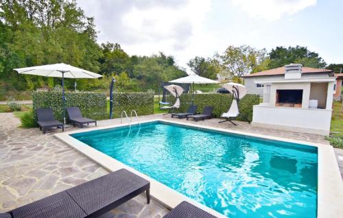 einen Pool mit Stühlen und Sonnenschirmen im Hof in der Unterkunft Großes Ferienhaus in Buroli mit Privatem Pool in Buroli