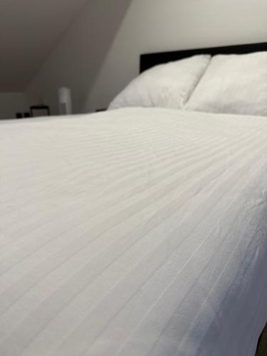 a close up of a bed with white sheets at Modernes Loft am Dreiländereck in Alsdorf