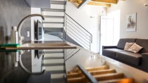 - un salon avec un escalier et un canapé dans l'établissement Wohnung in Toscolano Maderno mit Garten, Grill und Terrasse, à Toscolano Maderno