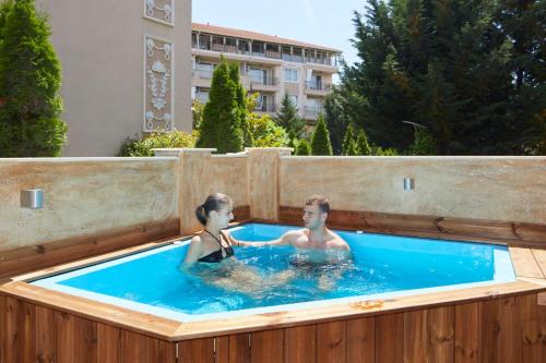 a man and a woman in a hot tub at Feniks Apartments in Nesebar