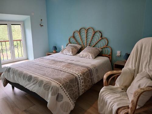 a bedroom with a large bed and a chair at Gite du Vieux Tonneau in Cerdon