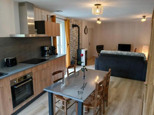 - une cuisine et une salle à manger avec une table et un canapé dans l'établissement Gite du Vieux Tonneau, à Cerdon