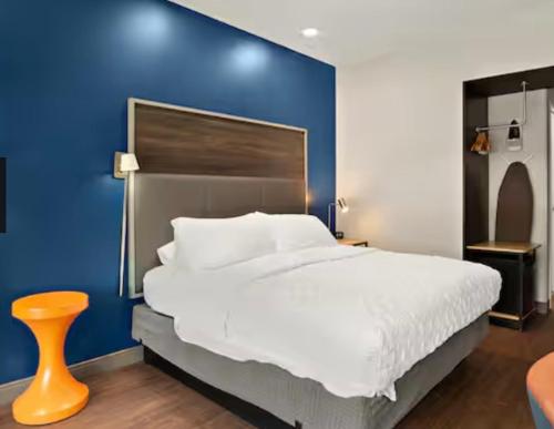 um quarto com uma cama grande e uma parede azul em Tru By Hilton em Santee