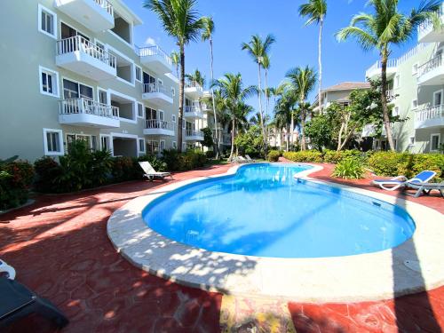 a swimming pool in front of a apartment building at CARAIBICO STUDIOS Beach Club & Pool in Punta Cana