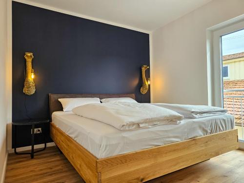 1 dormitorio con 1 cama grande y pared azul en BETTER modern apartment II Tischkicker I Balkon I Parkplatz en Altusried