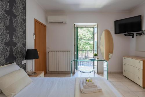 Schlafzimmer mit einem Bett, einem Tisch und einem TV in der Unterkunft Casa Bramare - YourPlace Abruzzo in Rocca San Giovanni