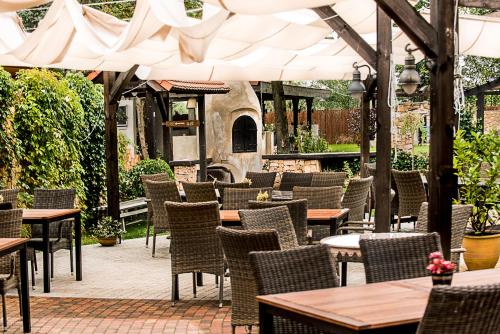 an outdoor patio with tables and chairs and a fireplace at Złoty Lin in Serock