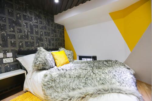 a bedroom with a yellow and gray wall at E104 Urban loft gem in Coventry