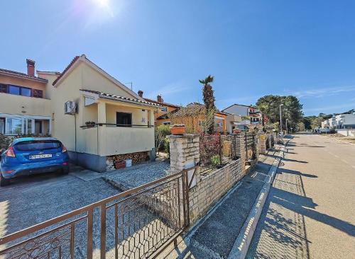 une voiture garée à côté d'une clôture à côté d'une maison dans l'établissement Ferienwohnung für 6 Personen ca 85 qm in Fažana, Istrien Istrische Riviera - b62465, à Fažana