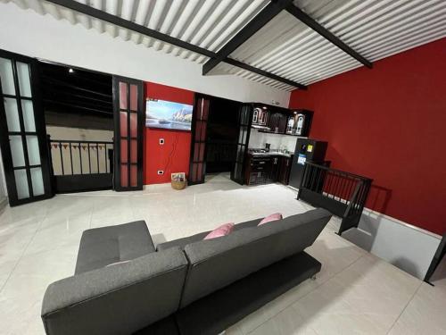 a living room with a couch and a red wall at Acogedor apartamento en el centro histórico de Guaduas in Guaduas