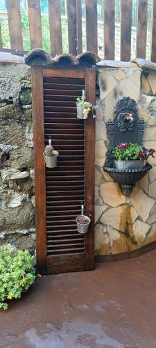 a gate with three potted plants on a stone wall at Dimora Garibaldina in Mentana