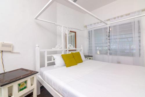 Warukenya في ماليندي: غرفة نوم بيضاء مع سرير أبيض مع وسائد صفراء