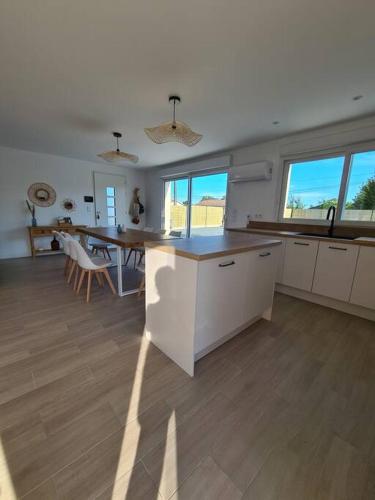 une cuisine avec une table et un comptoir dans l'établissement Maison récente, climatisée (8 pers.), à Soulac-sur-Mer