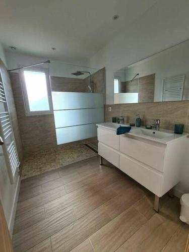 une salle de bain avec un lavabo et un grand miroir dans l'établissement Maison récente, climatisée (8 pers.), à Soulac-sur-Mer