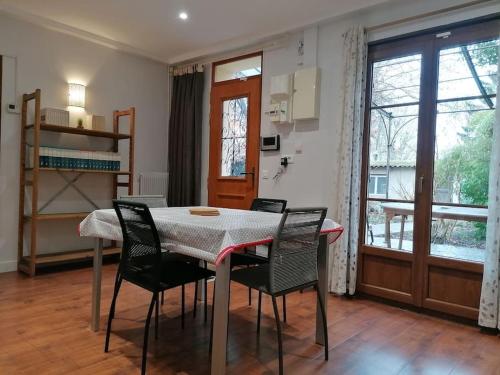 une salle à manger avec une table et quatre chaises dans l'établissement Maison individuelle au calme, à Montreuil
