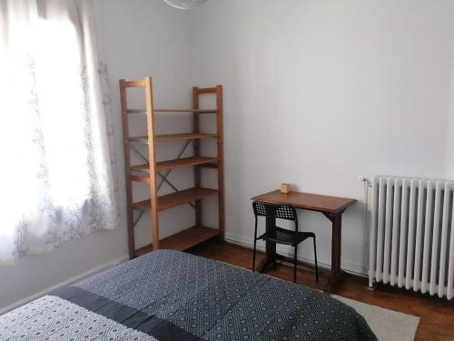 a bedroom with a bed and a desk and a table at Maison individuelle au calme in Montreuil