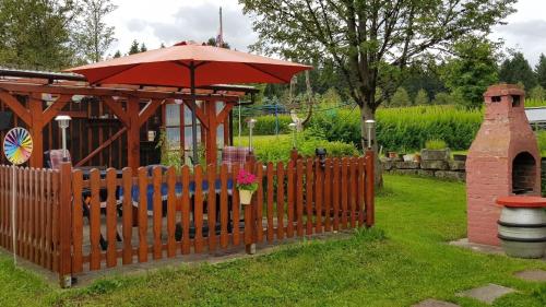 a wooden fence with an umbrella in a garden at Ferienzimmer im Thüringer Wald nahe dem Rennsteig in Siegmundsburg