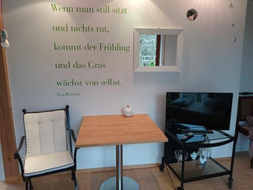 a room with a table and a sign on the wall at Pension Eltmann in Eltmann