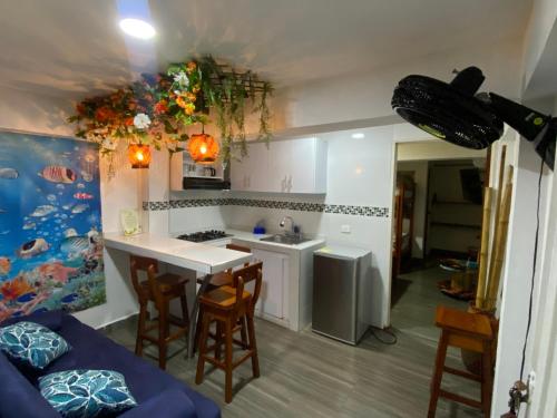 cocina con fregadero y mesa con sillas en Acuarios Hostal, en Playa Ladrilleros