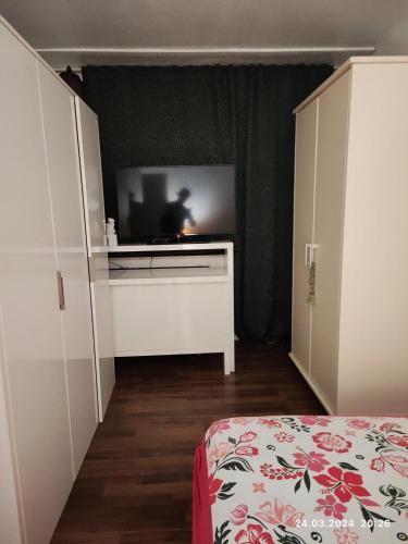 um quarto com uma televisão num quarto com uma cama em Altstadt Zimmer em Dusseldorf