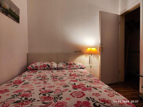 a bedroom with a bed with a floral bedspread at Altstadt Zimmer in Düsseldorf