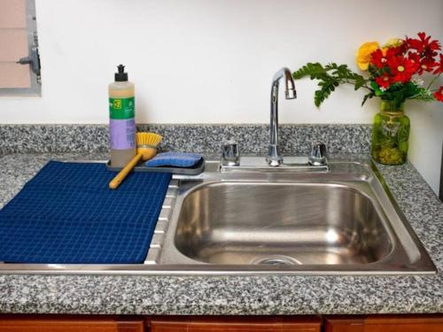 a kitchen sink with a blue towel next to it at Cozy Two Bedroom Apartment Near The U.S. Embassy in Antiguo Cuscatlán