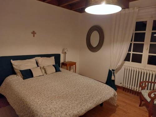 une chambre avec un lit, un miroir et une fenêtre dans l'établissement Maison de campagne Dordogne, à Les Lèches