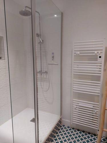 une douche avec une porte vitrée dans une salle de bain dans l'établissement Maison de campagne Dordogne, à Les Lèches