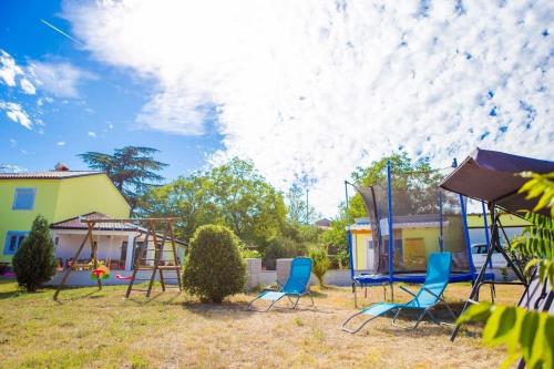 einen Spielplatz mit Stühlen und einer Schaukel im Hof in der Unterkunft Ferienhaus für 6 Personen ca 67 qm in Zminj, Istrien Binnenland von Istrien - b62427 in Žminj