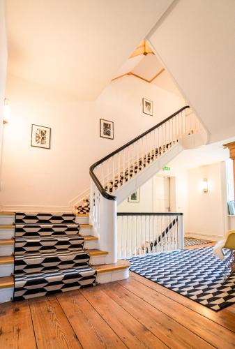 a staircase in a house with a blue and white carpet at Schloss Harkensee in Dassow
