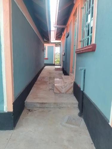 un couloir vide d'un bâtiment aux murs bleus dans l'établissement RUSINGA SUITES, à Mbita