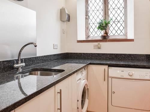 a kitchen with a sink and a dishwasher at Old St Lukes Church in Soulby