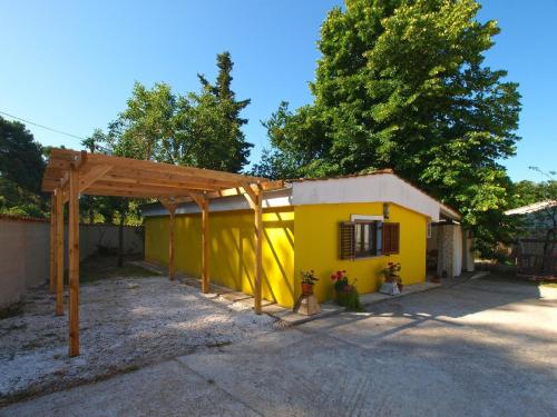 a small yellow house with a wooden pergola at Ferienwohnung für 3 Personen ca 34 qm in Banjole, Istrien Istrische Riviera in Banjole