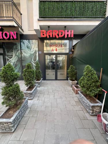 a entrance to a shopping mall with potted trees in front at City Center 1bedroom in Ferizaj