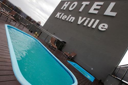 a hotel with a swimming pool in front of a building at Klein Ville São Leopoldo in São Leopoldo