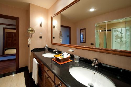 
a bathroom with two sinks and a mirror at Elba Estepona Gran Hotel & Thalasso Spa in Estepona
