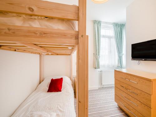 a bedroom with a bunk bed with a red pillow at Pegasus in Falmouth
