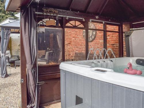 een hot tub in een prieel met twee rubberen elementen erin bij Little Lodge in Walcote