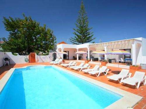 a swimming pool with white chairs and a resort at Casa Margarita in Altura