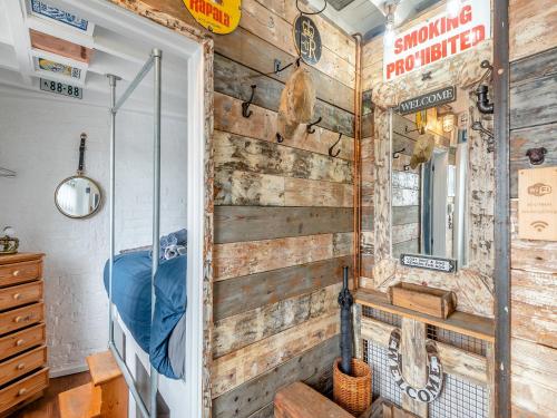 a room with a wooden wall with a mirror at Mill House in Trusthorpe