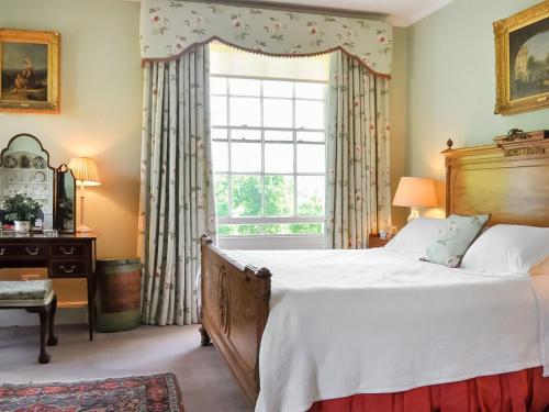 a bedroom with a large bed and a window at Glanusk Lodge - Uk46654 in Crickhowell