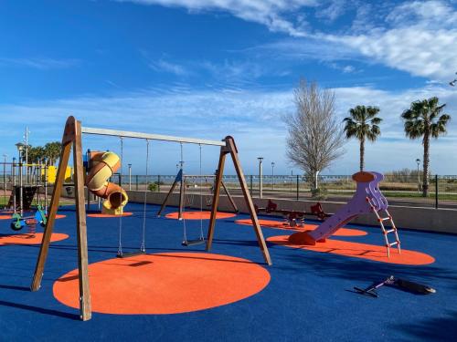a playground with slides and a swing at Apartamento La Sal Cubelles in Cubelles