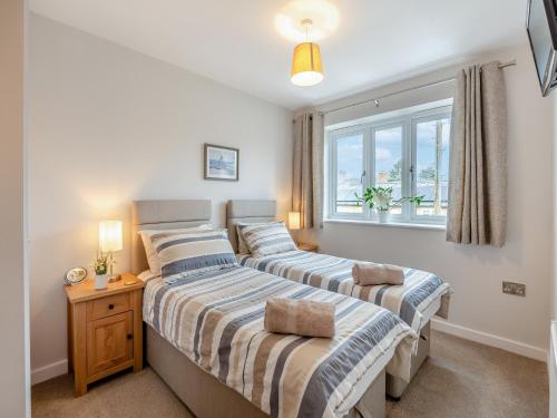 two beds in a bedroom with a window at Riverview in Market Deeping